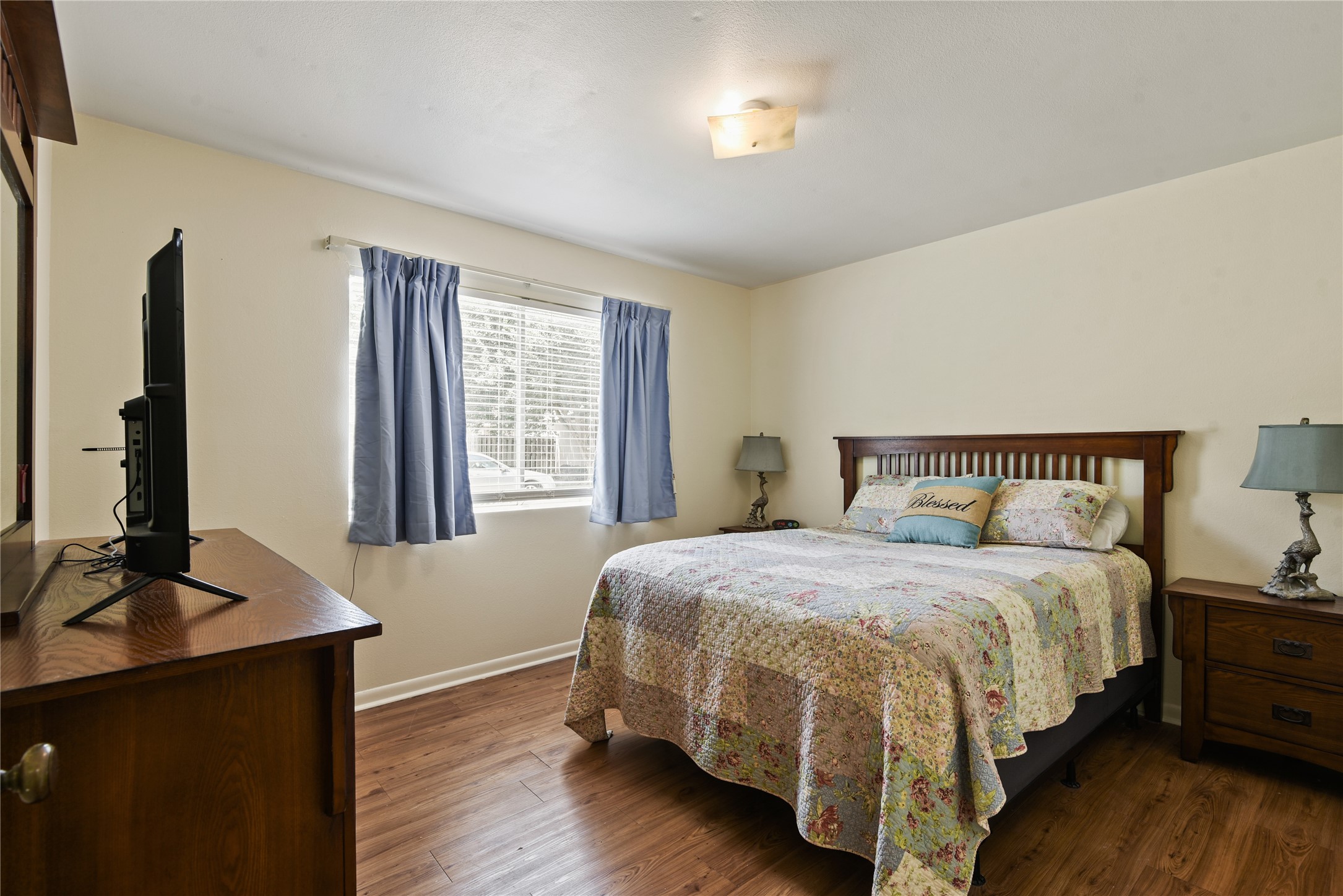 546 Georgetown Street, Unit 4 Beaumont, TX 77707 - Photo 11 of 14 a bedroom with a bed lamp and a large window