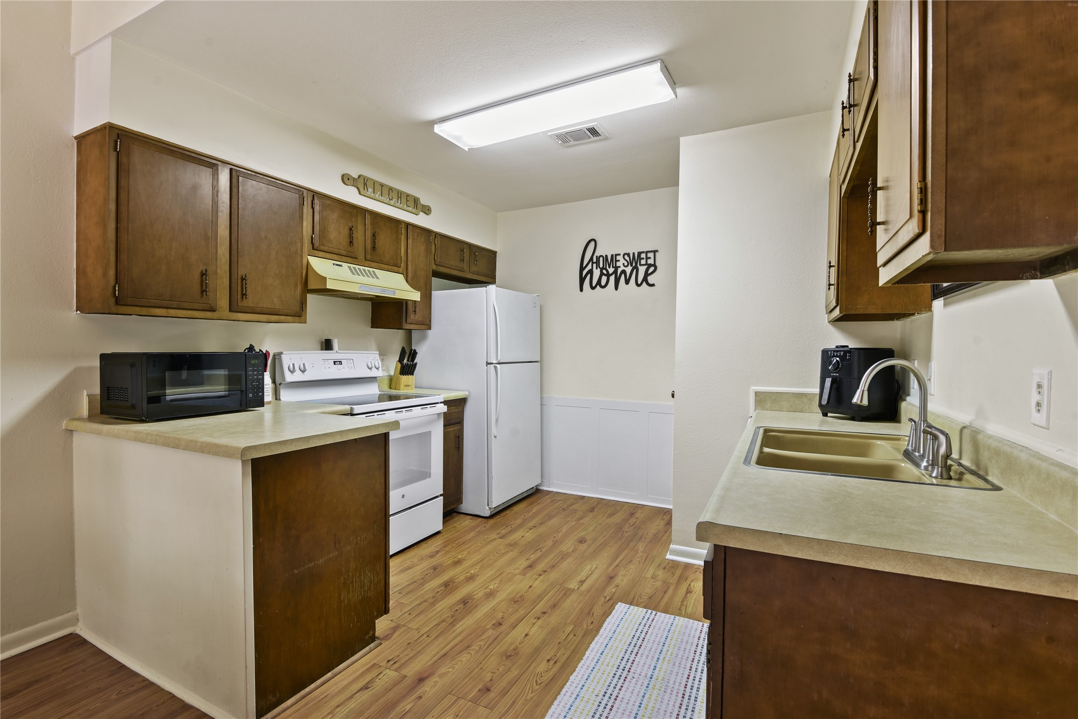 546 Georgetown Street, Unit 4 Beaumont, TX 77707 - Photo 9 of 14 a kitchen with a sink a stove and refrigerator
