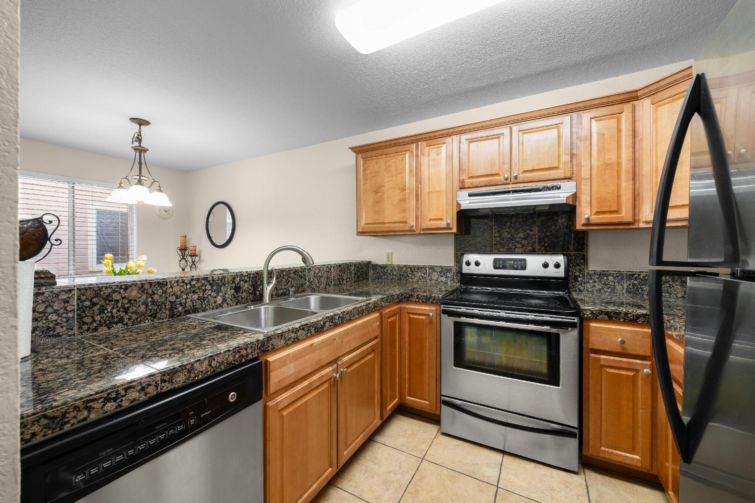 11150 Trinity River Drive, Unit 42 Rancho Cordova, CA 95670 - Photo 14 of 32 a kitchen with stainless steel appliances granite countertop a stove a sink and a microwave