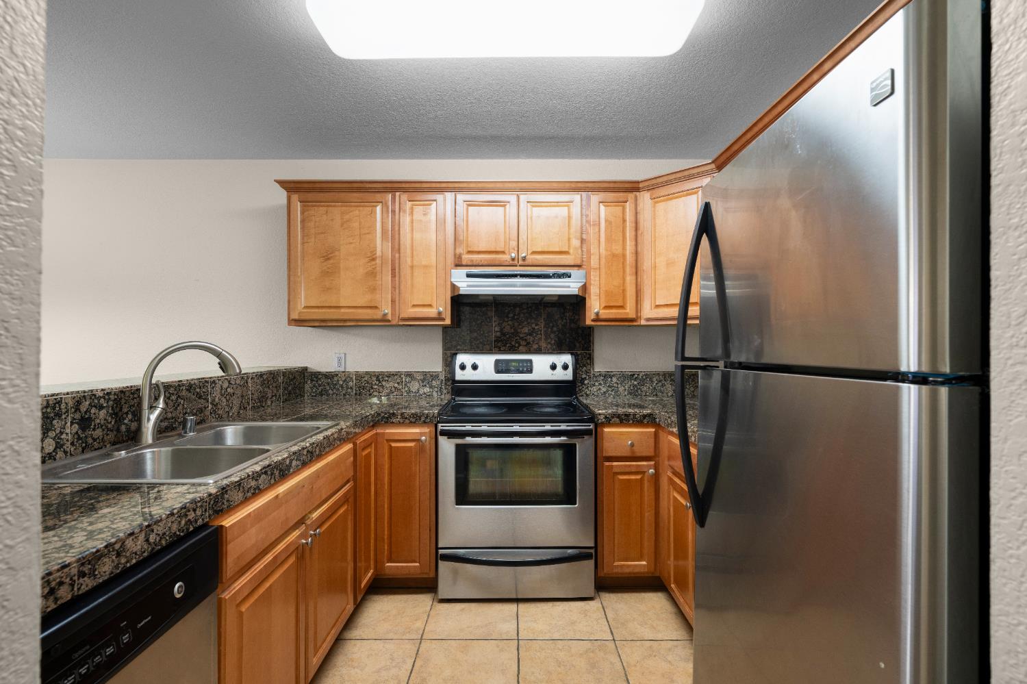 11150 Trinity River Drive, Unit 42 Rancho Cordova, CA 95670 - Photo 15 of 32 a kitchen with stainless steel appliances granite countertop a sink stove and refrigerator