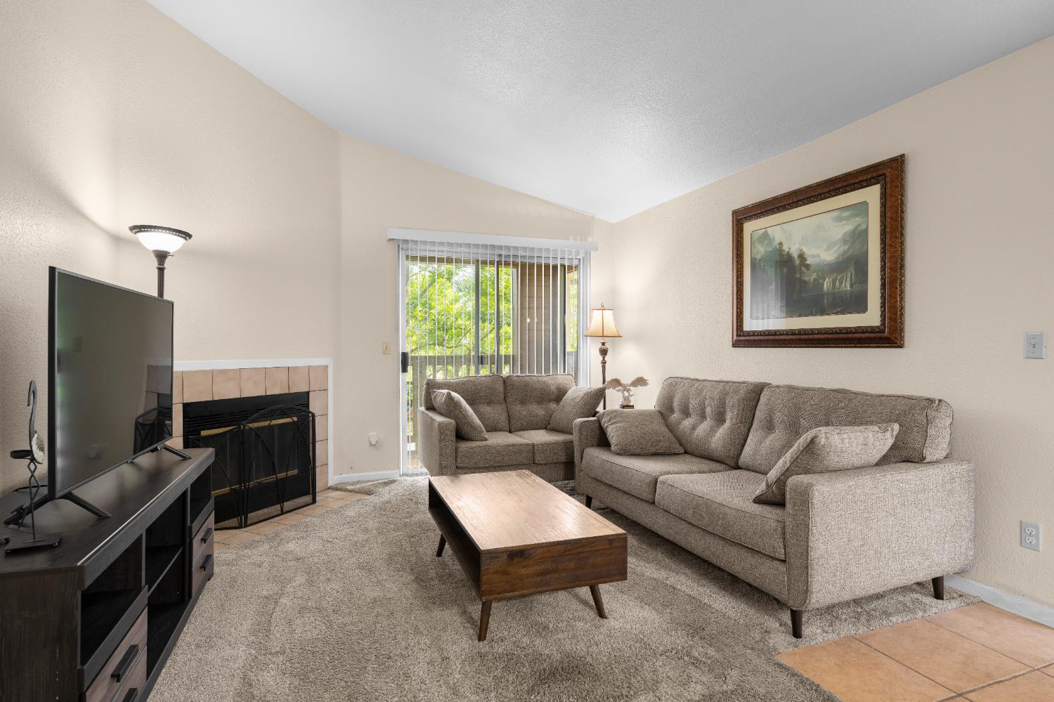 11150 Trinity River Drive, Unit 42 Rancho Cordova, CA 95670 - Photo 6 of 32 a living room with furniture a flat screen tv and a window