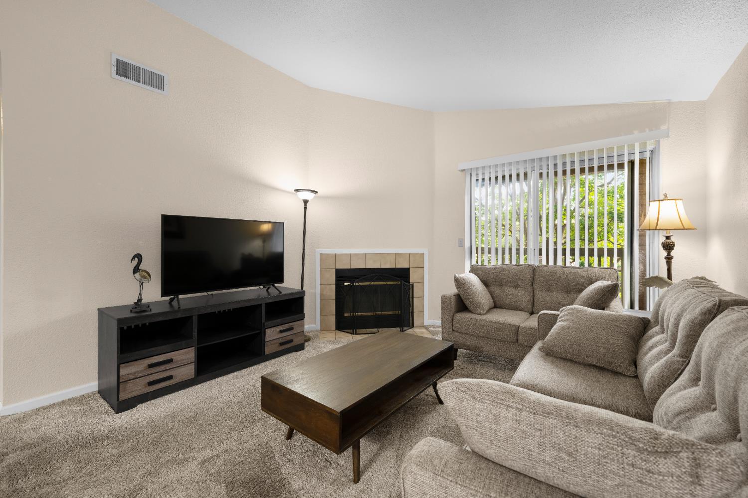 11150 Trinity River Drive, Unit 42 Rancho Cordova, CA 95670 - Photo 7 of 32 a living room with furniture a flat screen tv and a fireplace