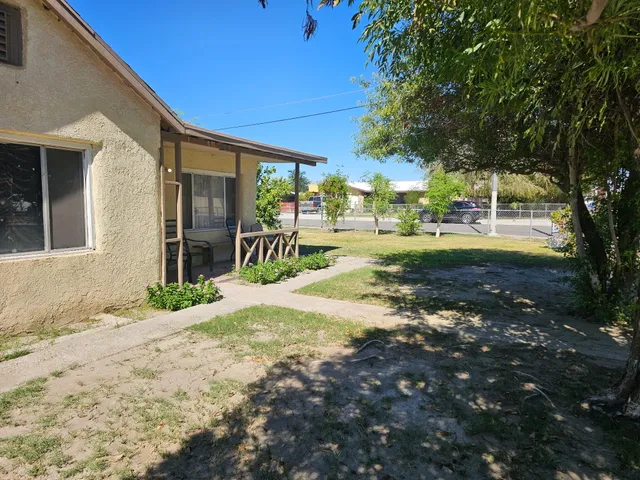 a view of a house with backyard and tree