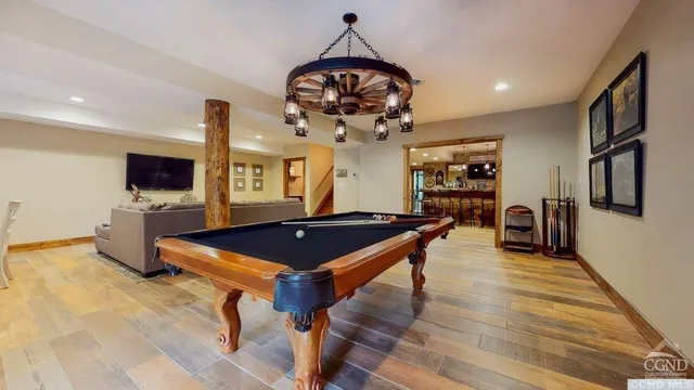 a room with pool table flat screen tv and windows