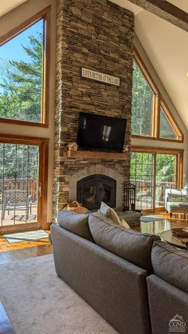 a living room with furniture a large window and a fireplace