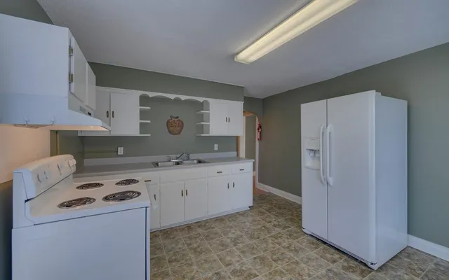 a kitchen with a stove a refrigerator and a sink