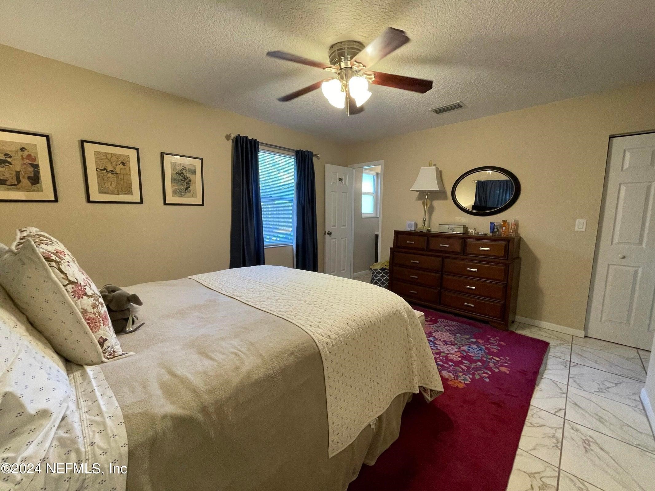 425 Gerona Road St. Augustine, FL 32086 - Photo 17 of 26 a bedroom with a bed and a chandelier