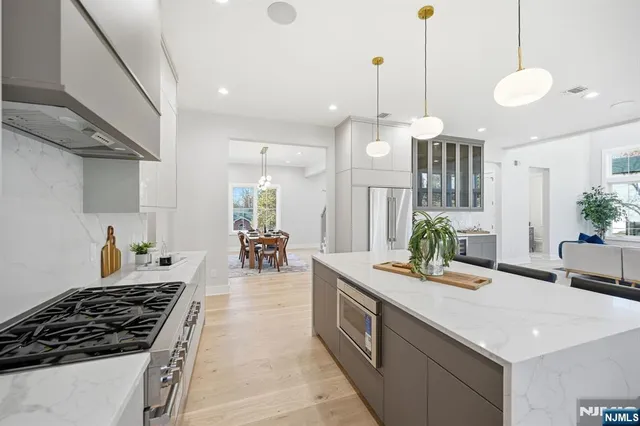 a kitchen with stainless steel appliances a stove a sink a dining table and chairs