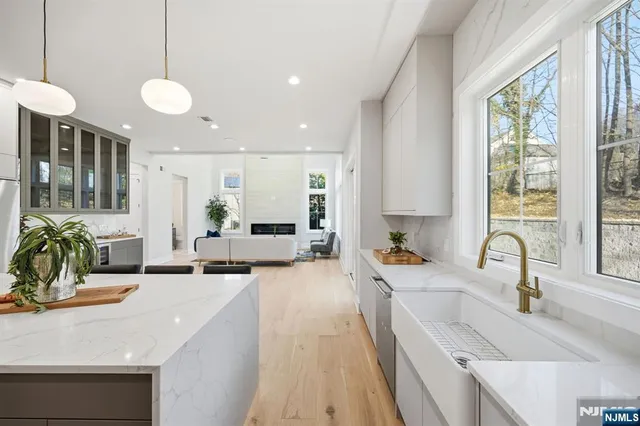 a large kitchen with sink a counter top space and living room view