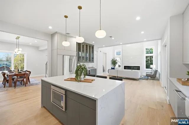 a large kitchen with kitchen island a large counter top a dining table and chairs