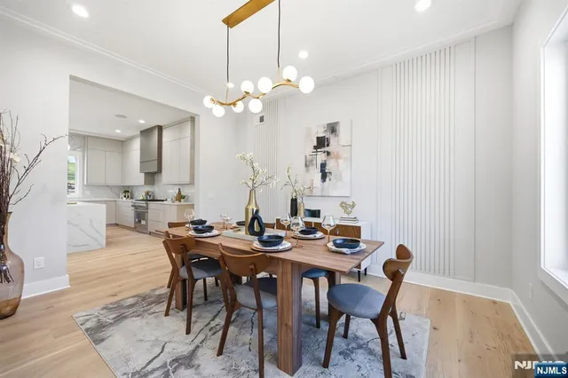 a view of a a dining room with furniture a rug and wooden floor