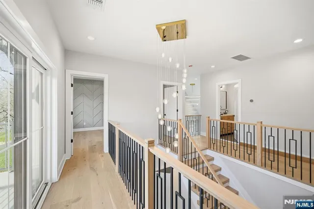 a view of a hallway with wooden floor and windows