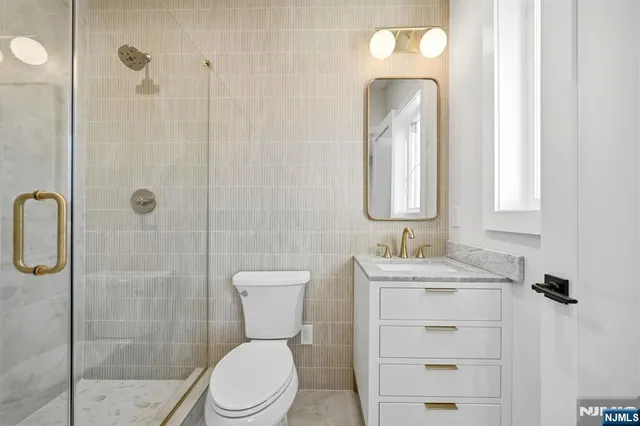 a bathroom with a double vanity sink toilet mirror and bathtub