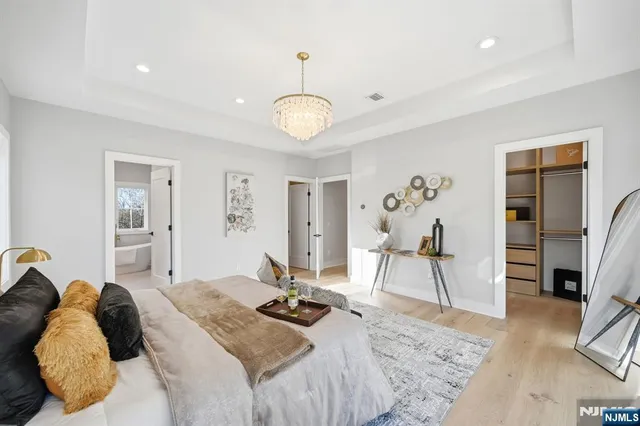 a spacious bathroom with a double vanity sink large mirror and a bathtub