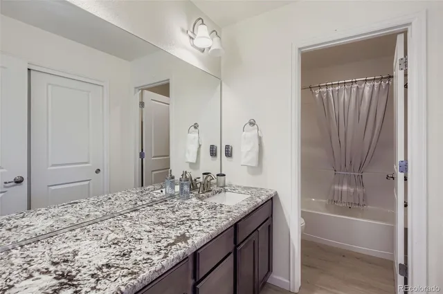 a bathroom with a granite countertop sink and a mirror