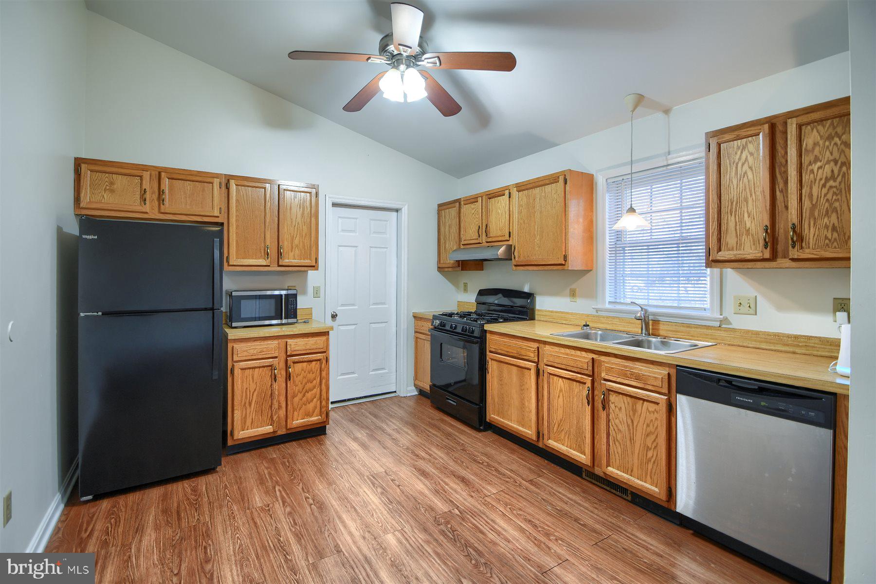401 Dalton Road Oxford, PA 19363 - Photo 15 of 37 a kitchen with stainless steel appliances granite countertop a refrigerator a sink dishwasher a stove with wooden cabinets and floor