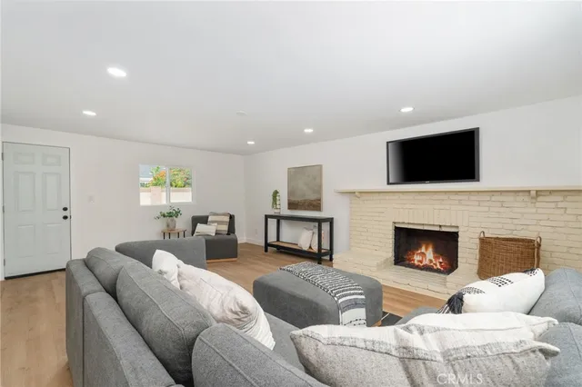 a living room with furniture a fireplace and flat screen tv