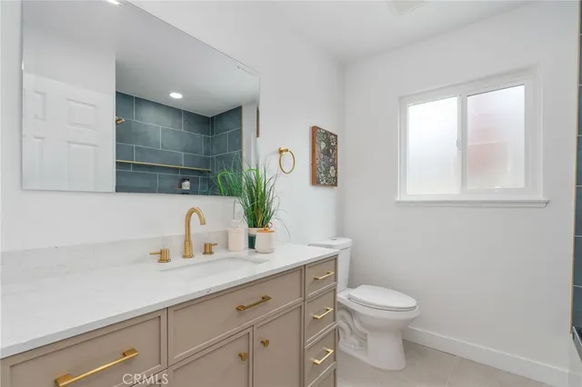 a bathroom with a granite countertop toilet sink and mirror