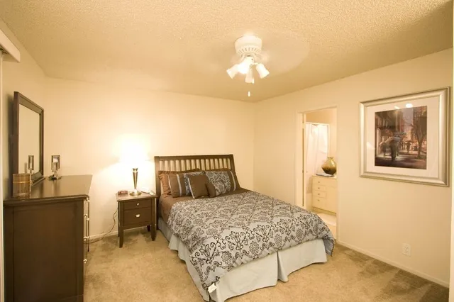 a bedroom with a large bed and a chandelier