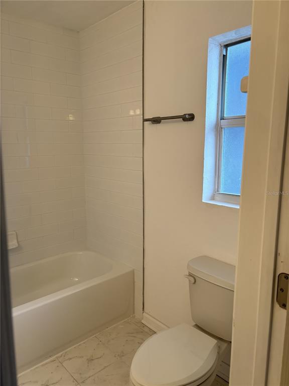 9030 Blind Pass Road, Unit C7 St. Petersburg, FL 33706 - Photo 12 of 16 a bathroom with a toilet and a bath tub