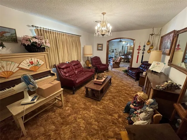 a living room with furniture gym equipment and a chandelier