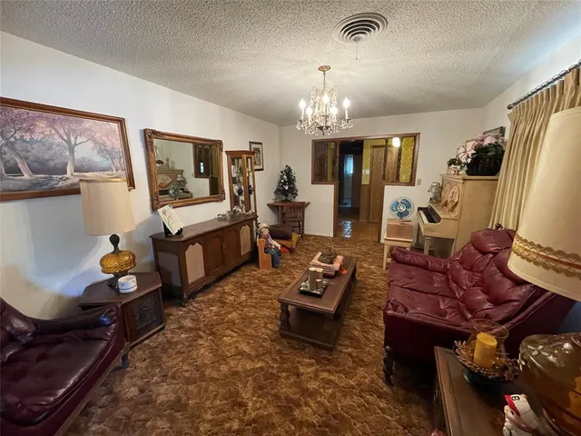 a living room with furniture a chandelier and a flat screen tv