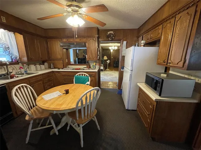 a kitchen with sink refrigerator dining table and chairs