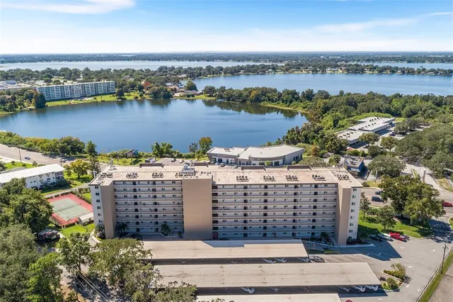 an aerial view of ocean and residential houses with outdoor space