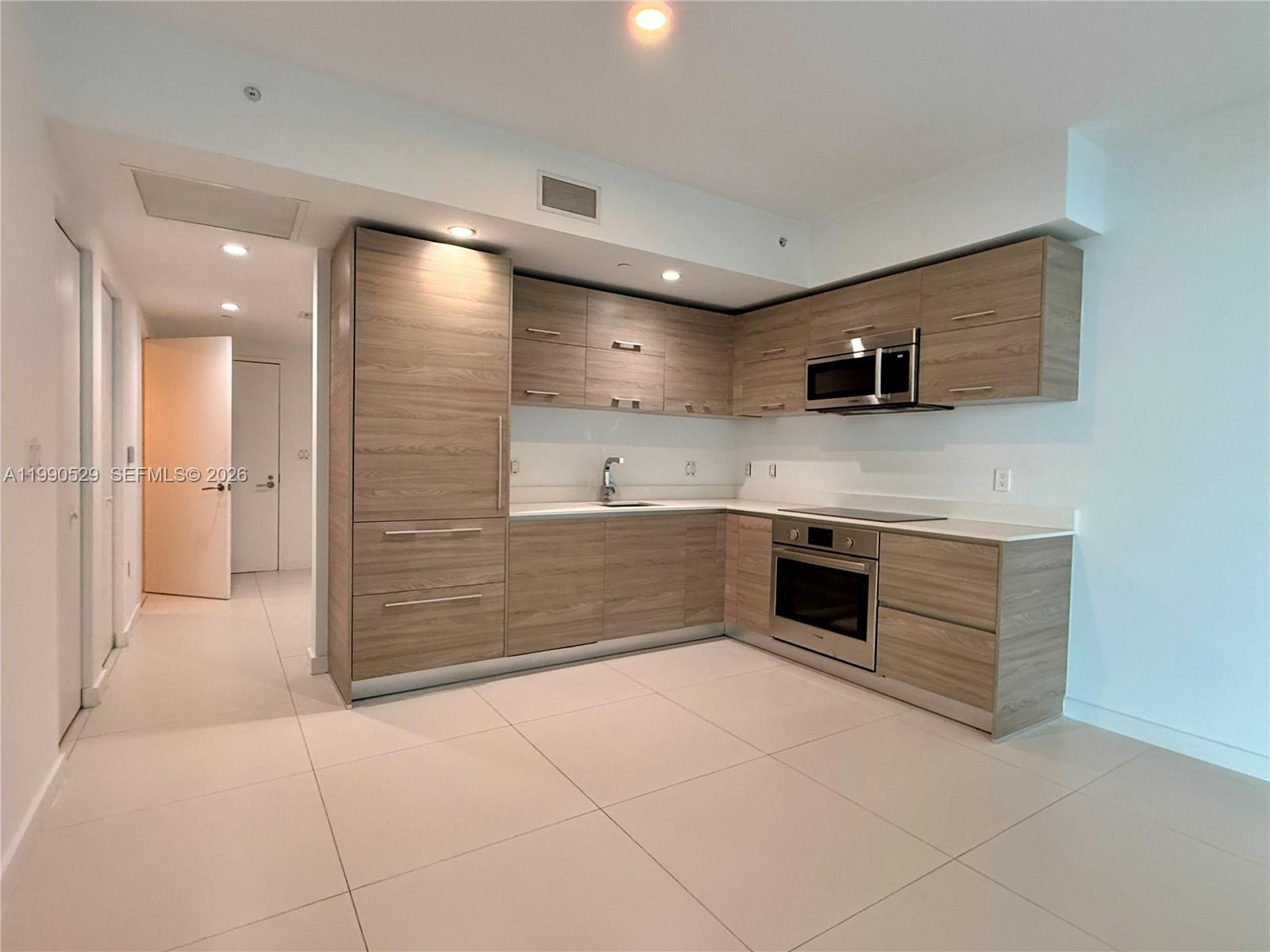 1300 South Miami Avenue, Unit 2008 Miami, FL 33130 - Photo 13 of 29 a large kitchen with a stove and a sink
