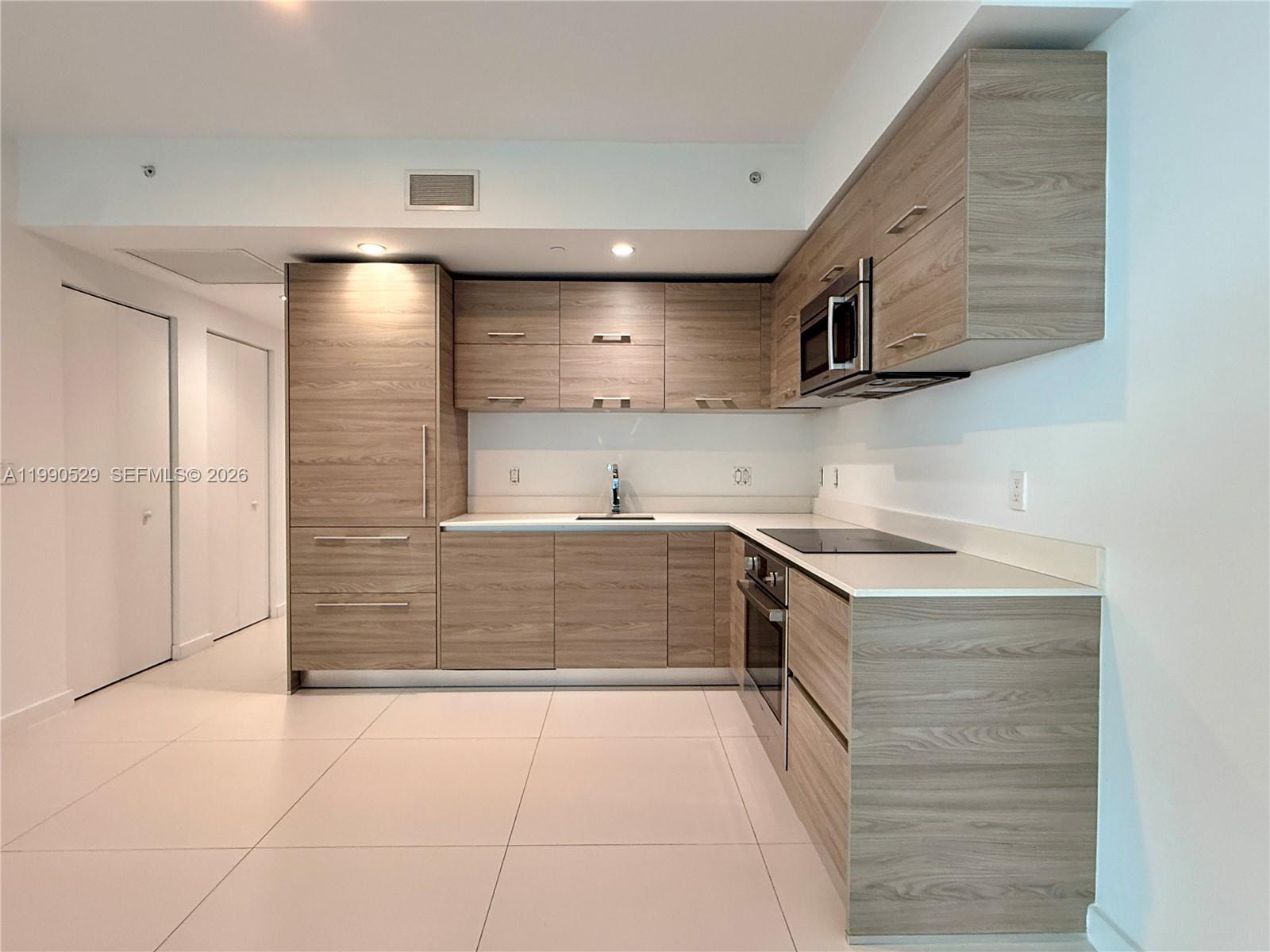 1300 South Miami Avenue, Unit 2008 Miami, FL 33130 - Photo 14 of 29 a kitchen with stainless steel appliances granite countertop a stove and a sink