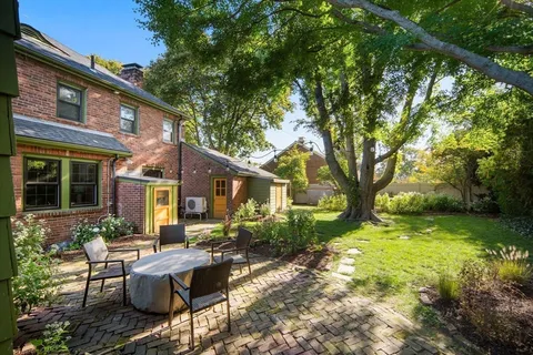 a view of a house with backyard sitting area and garden