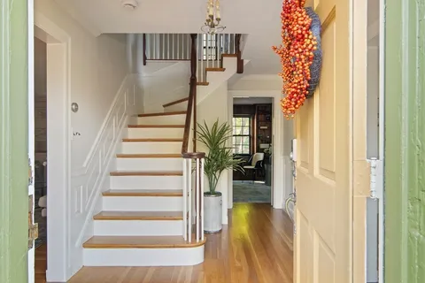 a view of entryway and hall with wooden floor