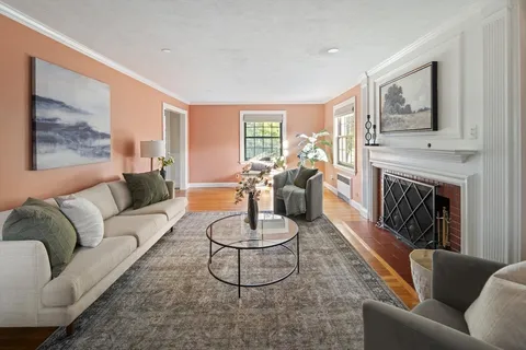 a living room with furniture fireplace and a large window