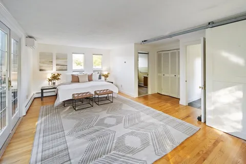 a spacious bedroom with a bed and large windows