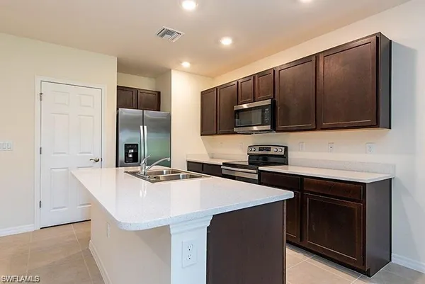 a kitchen with stainless steel appliances a sink stove and refrigerator