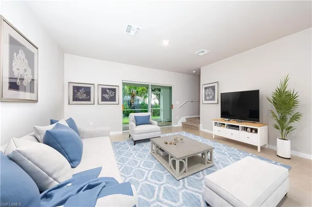 a living room with furniture a rug and a flat screen tv