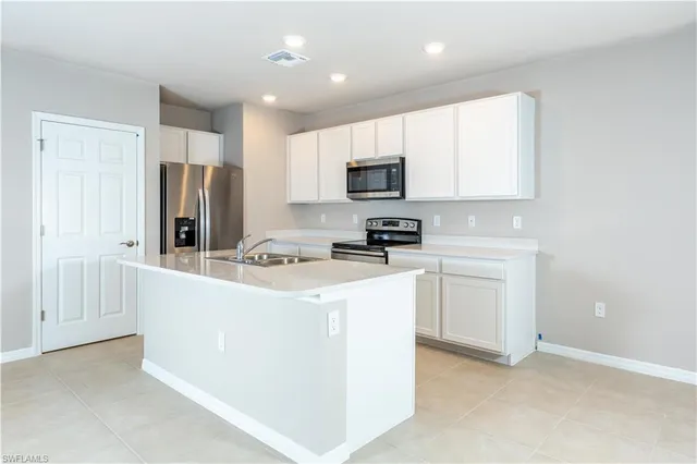 a kitchen with stainless steel appliances a refrigerator stove microwave and sink