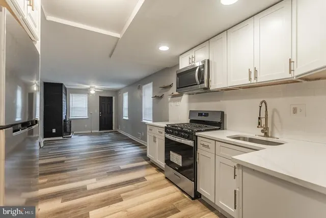 a kitchen with stainless steel appliances granite countertop a stove a sink and a refrigerator