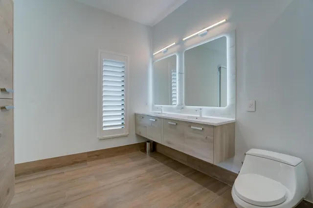a bathroom with a toilet sink and mirror