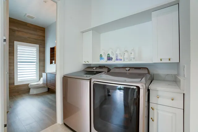 a utility room with wooden floor washer and dryer