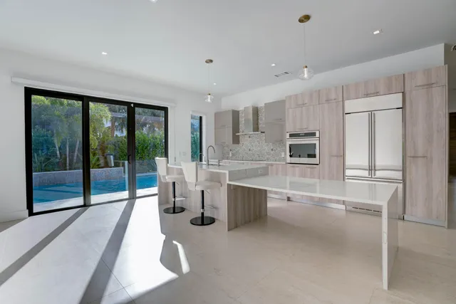 a large kitchen with kitchen island a large window