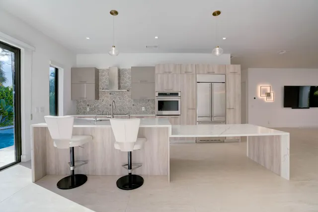 a kitchen with stainless steel appliances kitchen island granite countertop a sink and a refrigerator