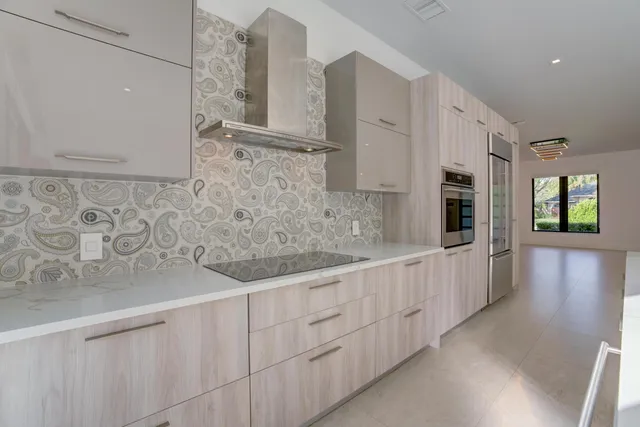 a kitchen with stainless steel appliances granite countertop white cabinets and window