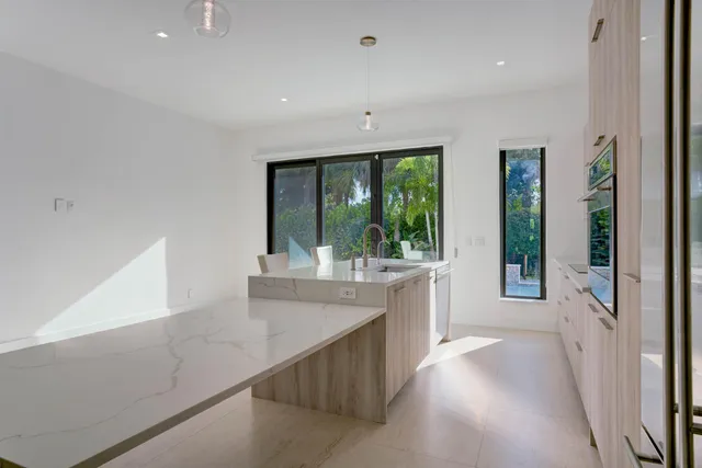 a view of a kitchen with a sink and large window