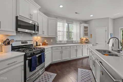 a kitchen with white cabinets and stainless steel appliances
