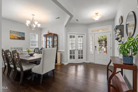 a view of a dining room with furniture a chandelier and wooden floor