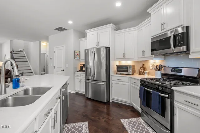 a kitchen with white cabinets and stainless steel appliances