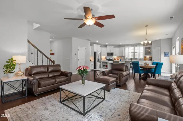 a kitchen with stainless steel appliances granite countertop a dining table chairs refrigerator microwave and cabinets