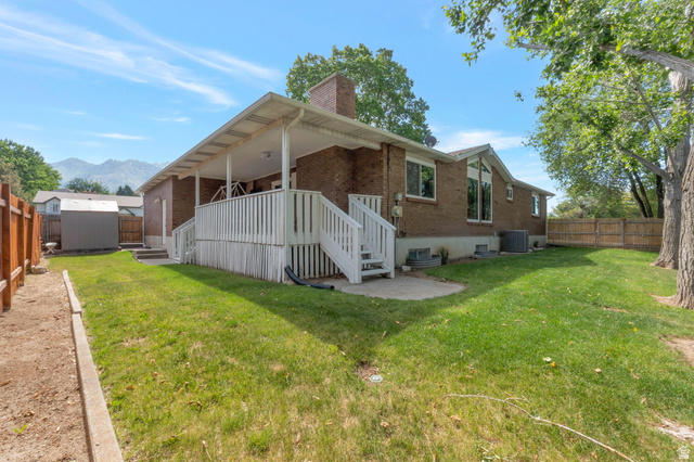 11072 Windy Peak Ridge Drive, Unit 32 Sandy, UT 84094 - Photo 3 of 30 Rear brick exterior featuring a covered porch with white railing and stairs