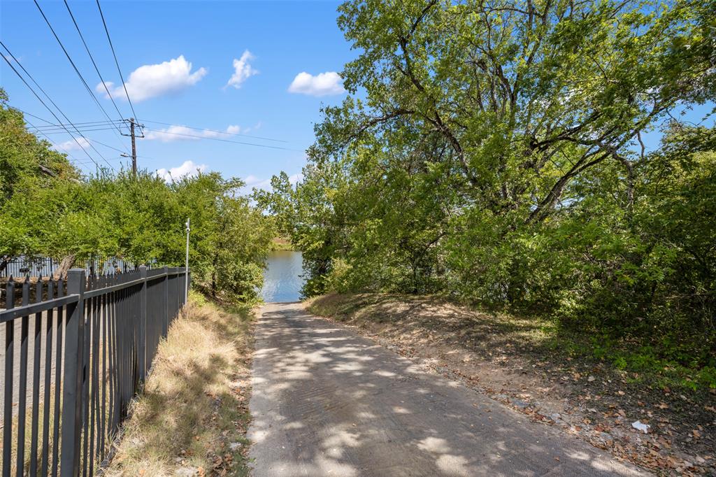 2210 Red Fox Road Austin, TX 78734 - Photo 38 of 40 A private boat ramp leads to the water, surrounded by lush trees and a clear sky.